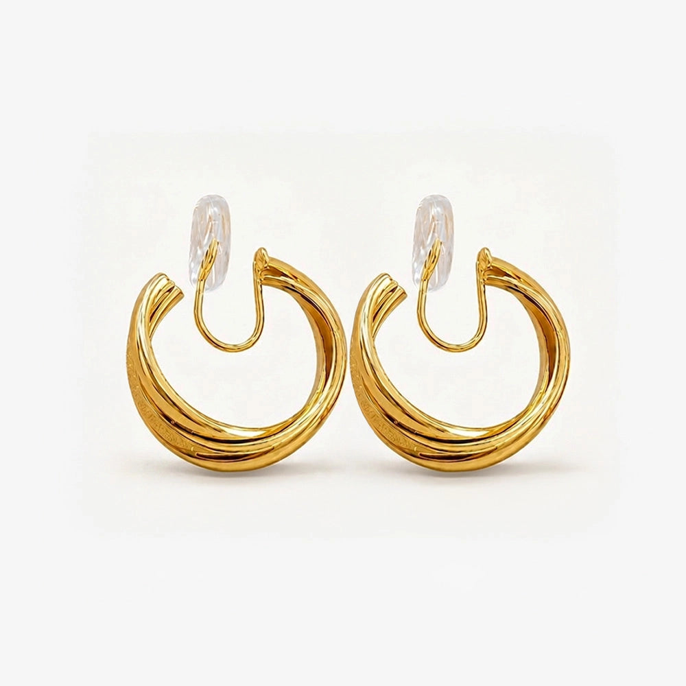 A pair of layered gold wave clip-on hoop earrings with a mosquito coil back, shown isolated on a clean white background.