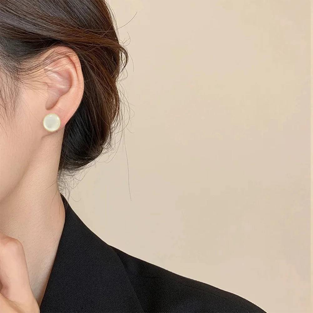 A close-up of a model's ear wearing a Lumi Frosted Moonstone invisible clip-on earring, showcasing its subtle elegance and comfortable fit.