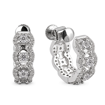 A pair of silver huggie hoop earrings adorned with multiple round-cut and pavé-set clear stones, shown from both the front and side angles on a white background.