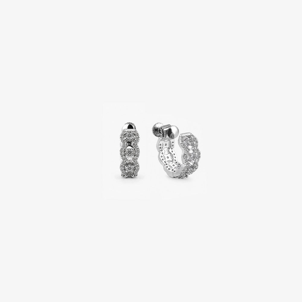 A pair of Luxe Iced Out Pavé Wave Clip-On Hoop Earrings in silver, displaying the detailed moissanite setting and secure screw-back closures.