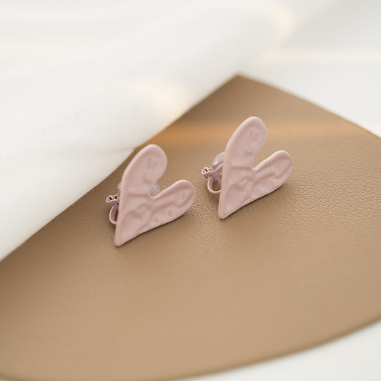 These Heart Clip On Earrings exude whimsy with a romantic flair. In a lovely pink shade, their unique irregular heart shapes are fashioned from resilient alloy. The hinge-back closure ensures easy wear. Perfect for adding a Barbie-esque playful note to any outfit.