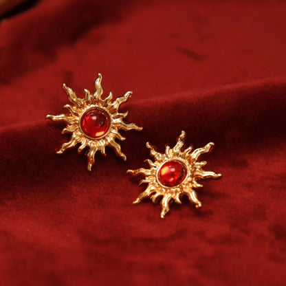  Gold sun clip-on earrings with fiery red gems. Hinged back for non-pierced ears. Embrace the celestial trend. celestial jewelry.