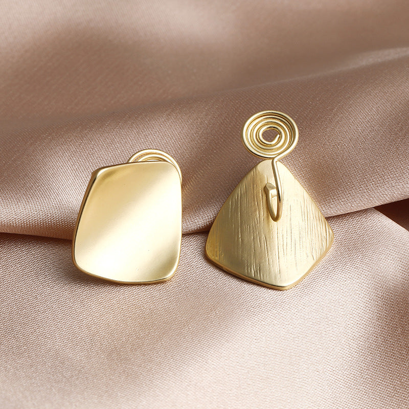 Gold square clip-on earrings with a chunky, geometric design. Crafted from alloy with a secure coil closure for comfortable wear. These statement earrings are perfect for those who love to embrace bold OOTD choices.