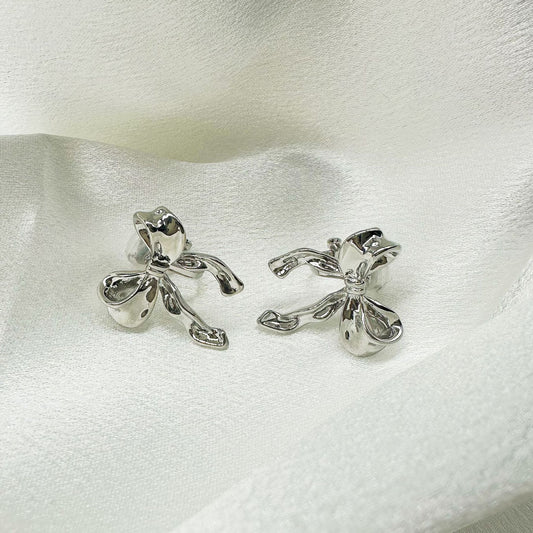 Silver bow clip-on stud earrings add a touch of timeless style to any outfit.  Hinge back closure for non pierced ears. A perfect everyday accessory for a touch of sophistication.