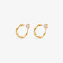 A pair of matte gold-toned organic abstract clip on hoop earrings shown from a frontal view.