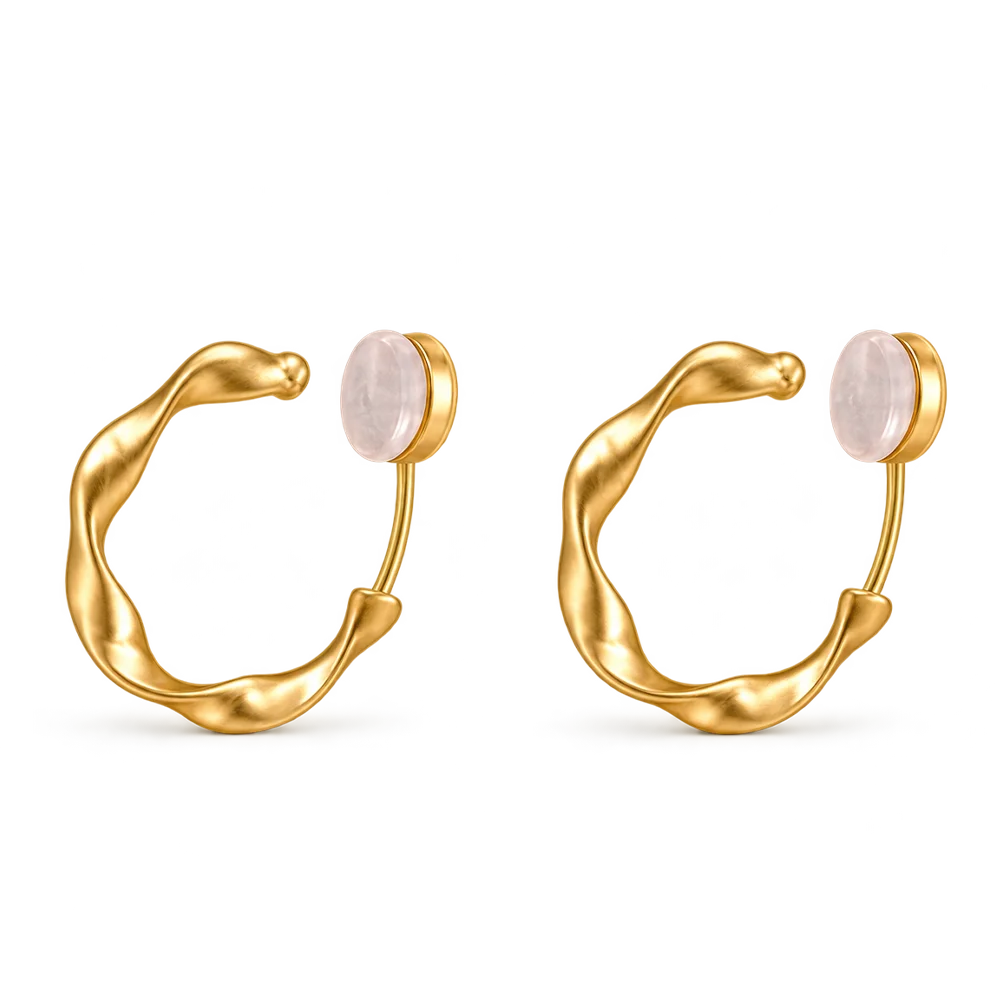 A pair of gold huggie hoop earrings with a smooth, organic wavy curve and a round pale pink stone set in each earring, shown on a plain white background.