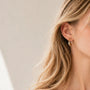 A office lady model wearing matte gold sculptural wavy clip on earrings, showing her professional look.
