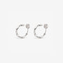 A pair of matte silver organic abstract clip-on hoop earrings with a soft satin finish.