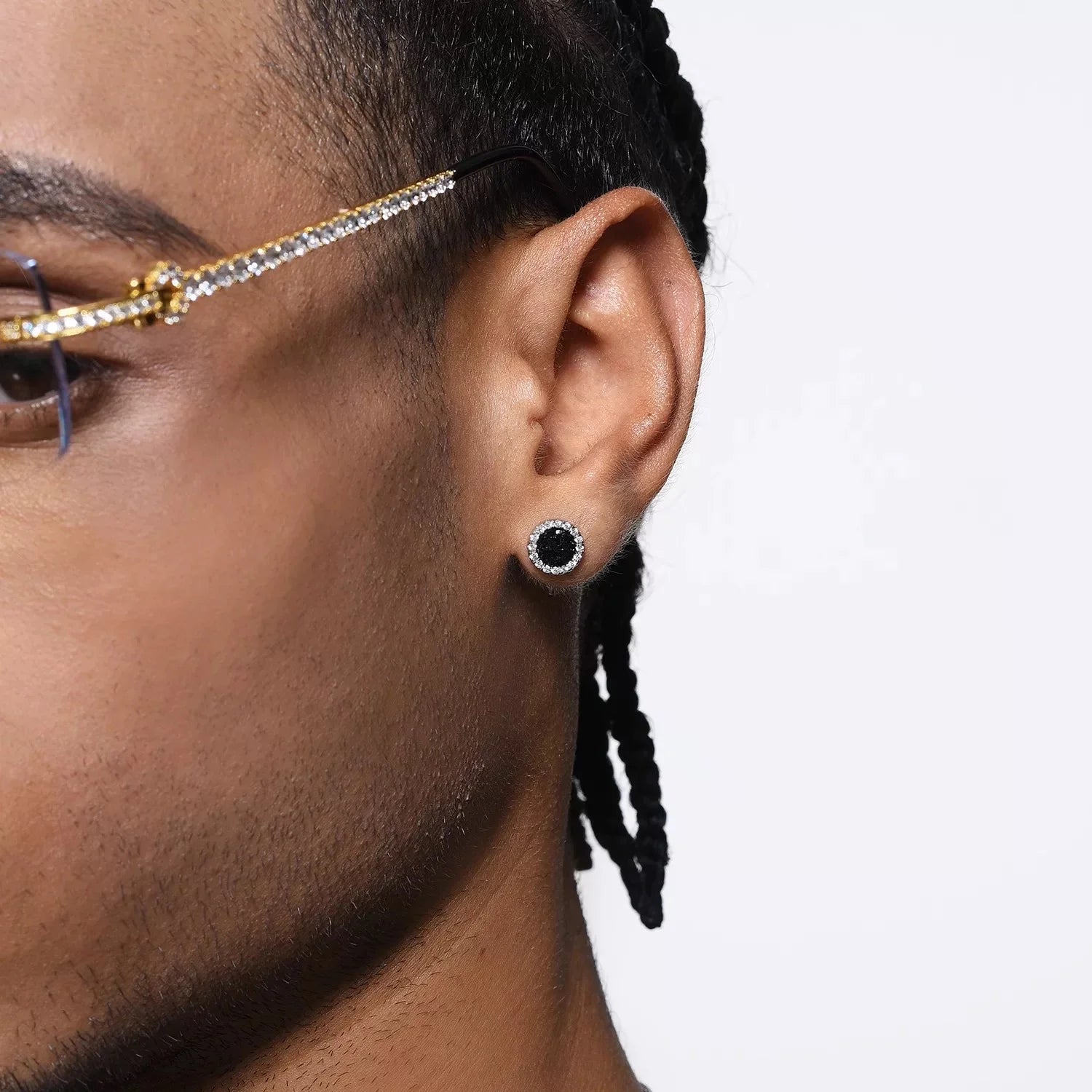 A close-up of a man's ear wearing a black crystal magnetic stud earring, demonstrating its bold and sparkling appearance on the earlobe.