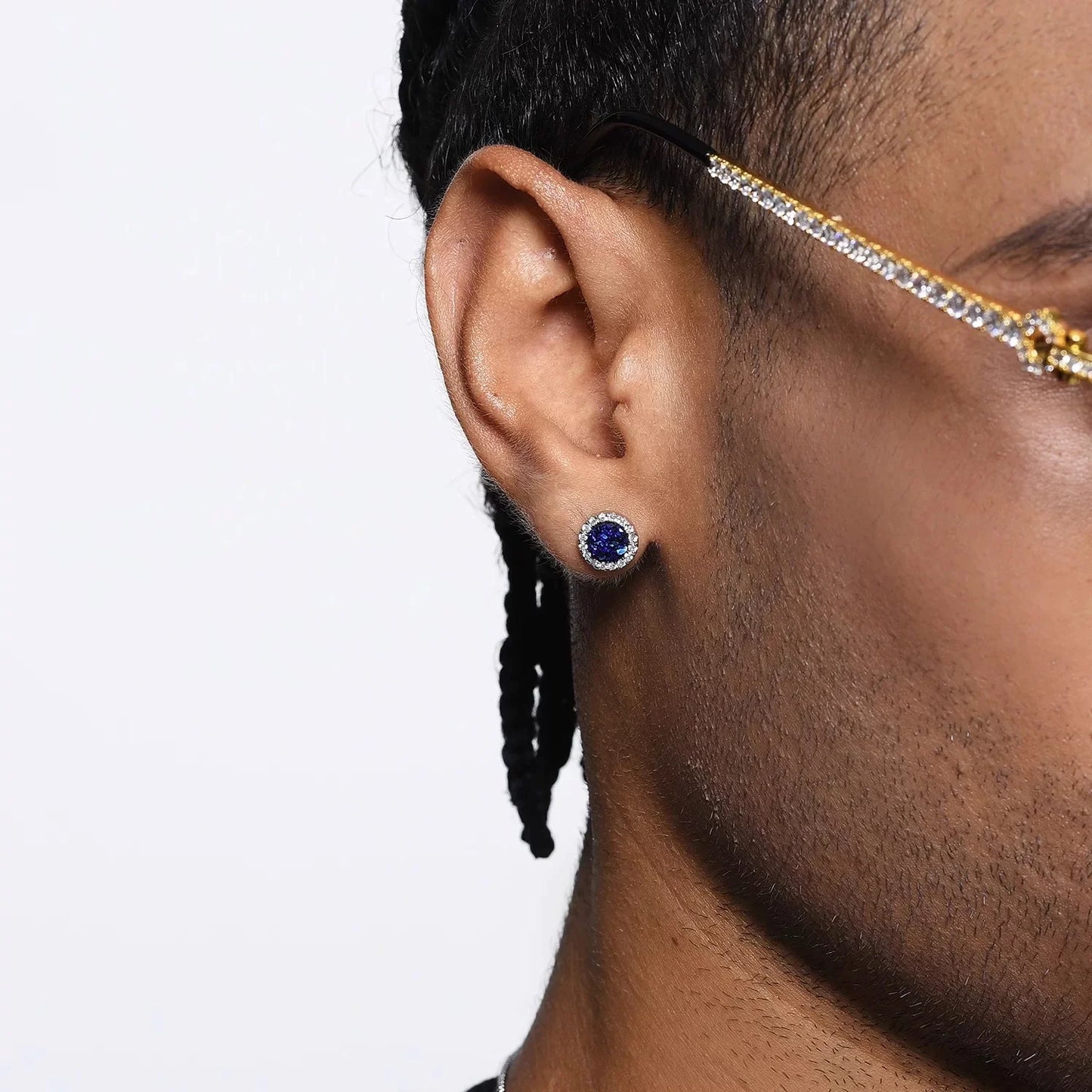 A close-up of a man's ear wearing an iridescent blue galaxy magnetic stud earring, demonstrating its vibrant color and sparkle on the earlobe.