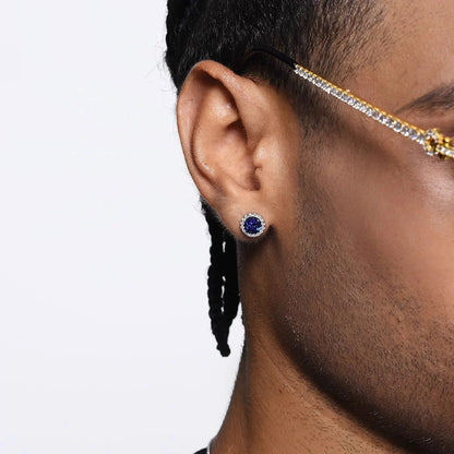A close-up of a man's ear wearing an iridescent blue galaxy magnetic stud earring, demonstrating its vibrant color and sparkle on the earlobe.