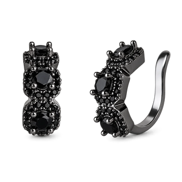 A pair of black huggie hoop earrings with three round black gemstones in prong settings, surrounded by small black pavé accents, shown on a plain white background.