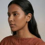 A fashion model wearing vintage-inspired gold clip-on earrings, showcasing the elegant fit and brilliant sparkle for bridal or evening wear.