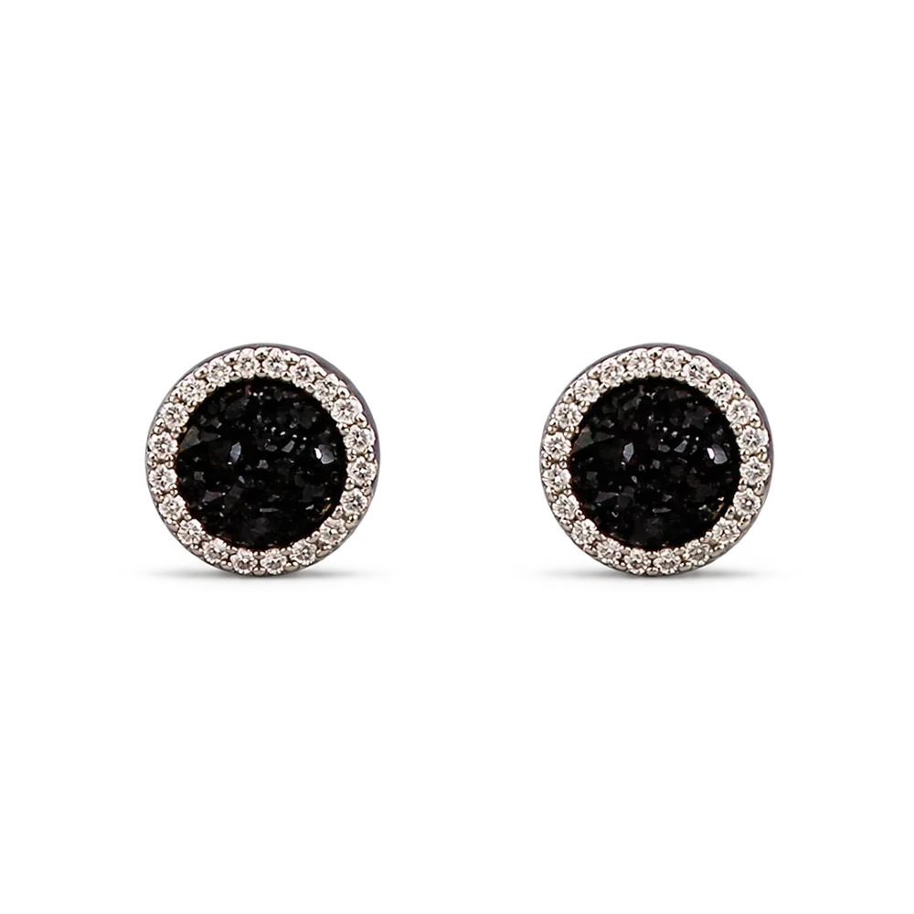 A pair of round stud earrings featuring textured black druzy centers surrounded by a halo of small clear stones in a silver-toned setting, shown on a plain white background.