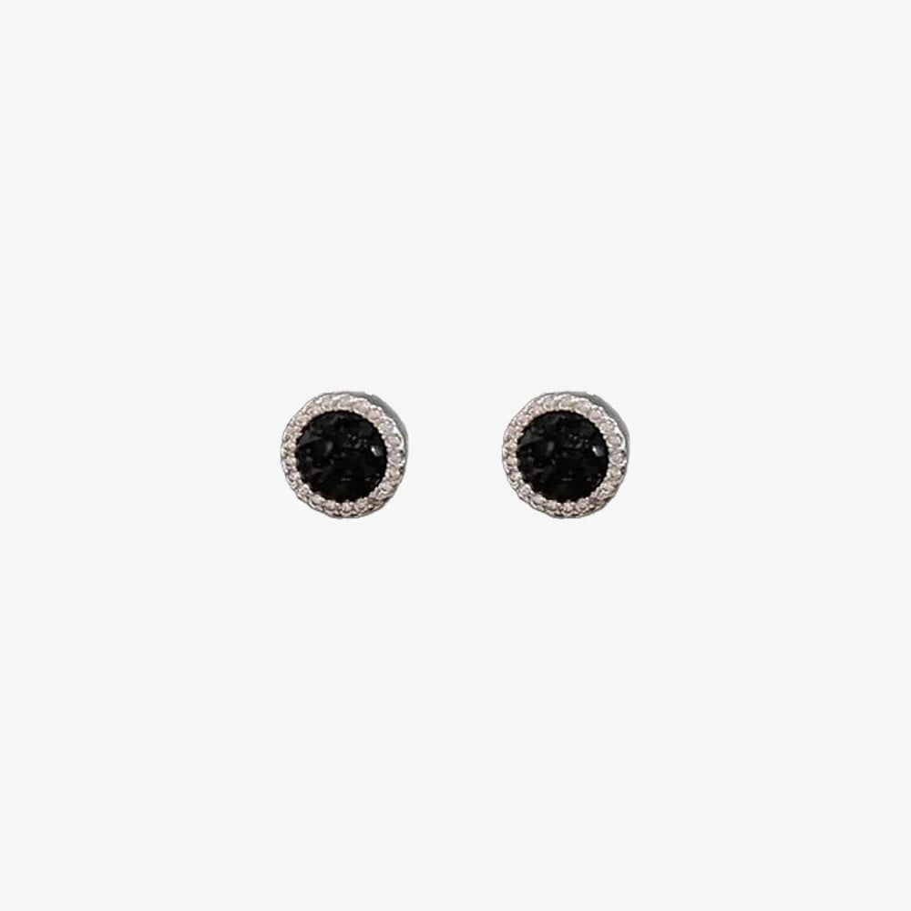 A pair of no-piercing black crystal magnetic stud earrings, highlighting their brilliant black center and pavé halo, isolated on a white background.