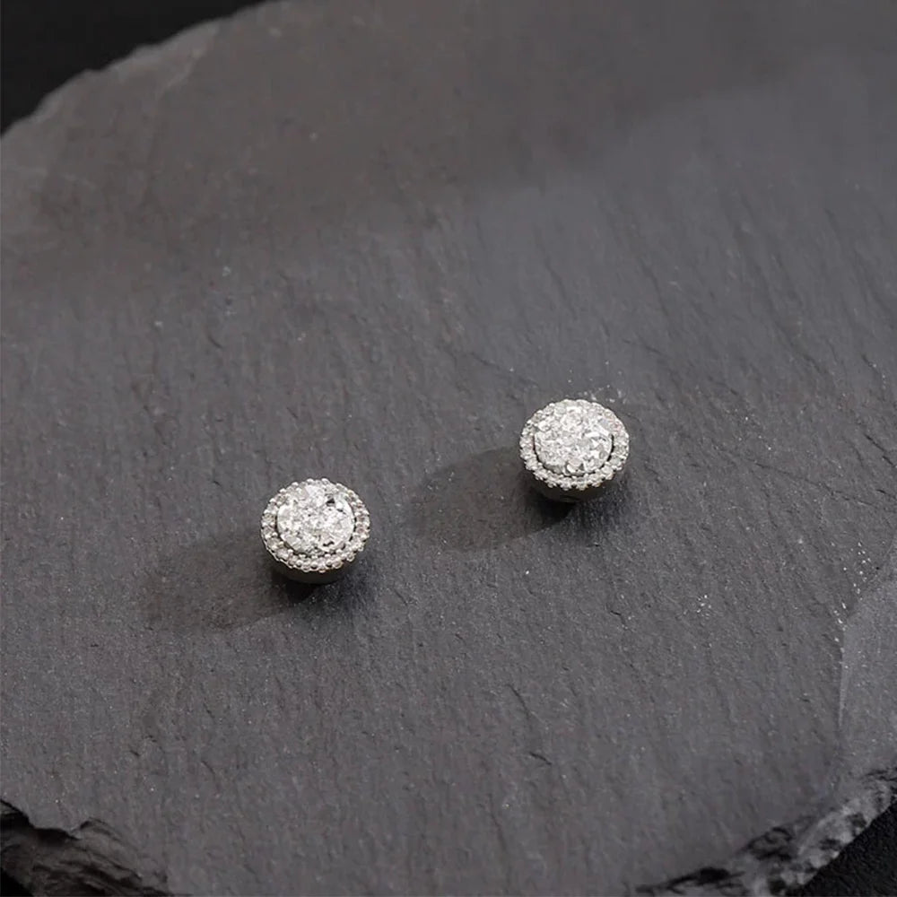 A pair of no-piercing diamond bling magnetic stud earrings, displaying their brilliant sparkle on a dark slate surface.