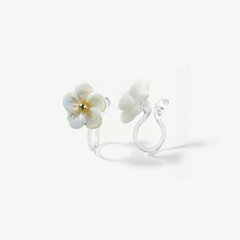 Close-up detail of a resin flower earring for non-pierced ears showing the transparent invisible clip-on back and pearlescent finish.
