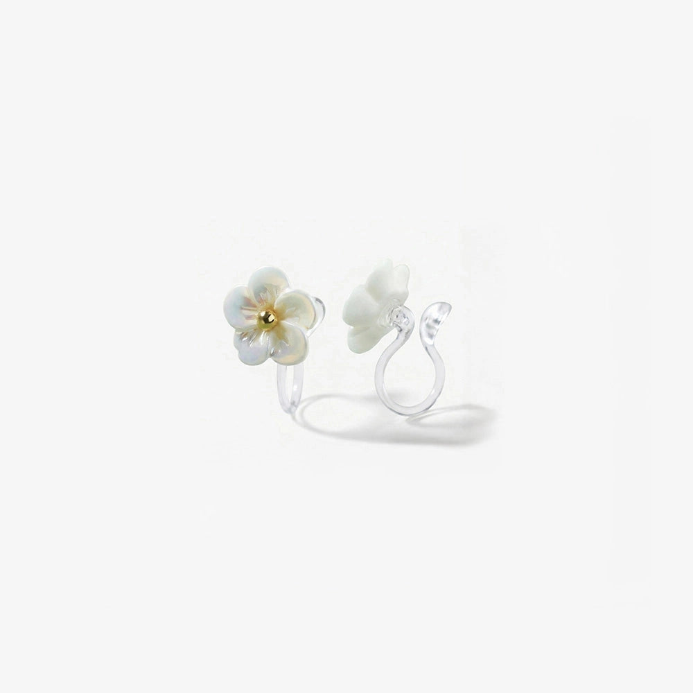 Close-up detail of a resin flower earring for non-pierced ears showing the transparent invisible clip-on back and pearlescent finish.