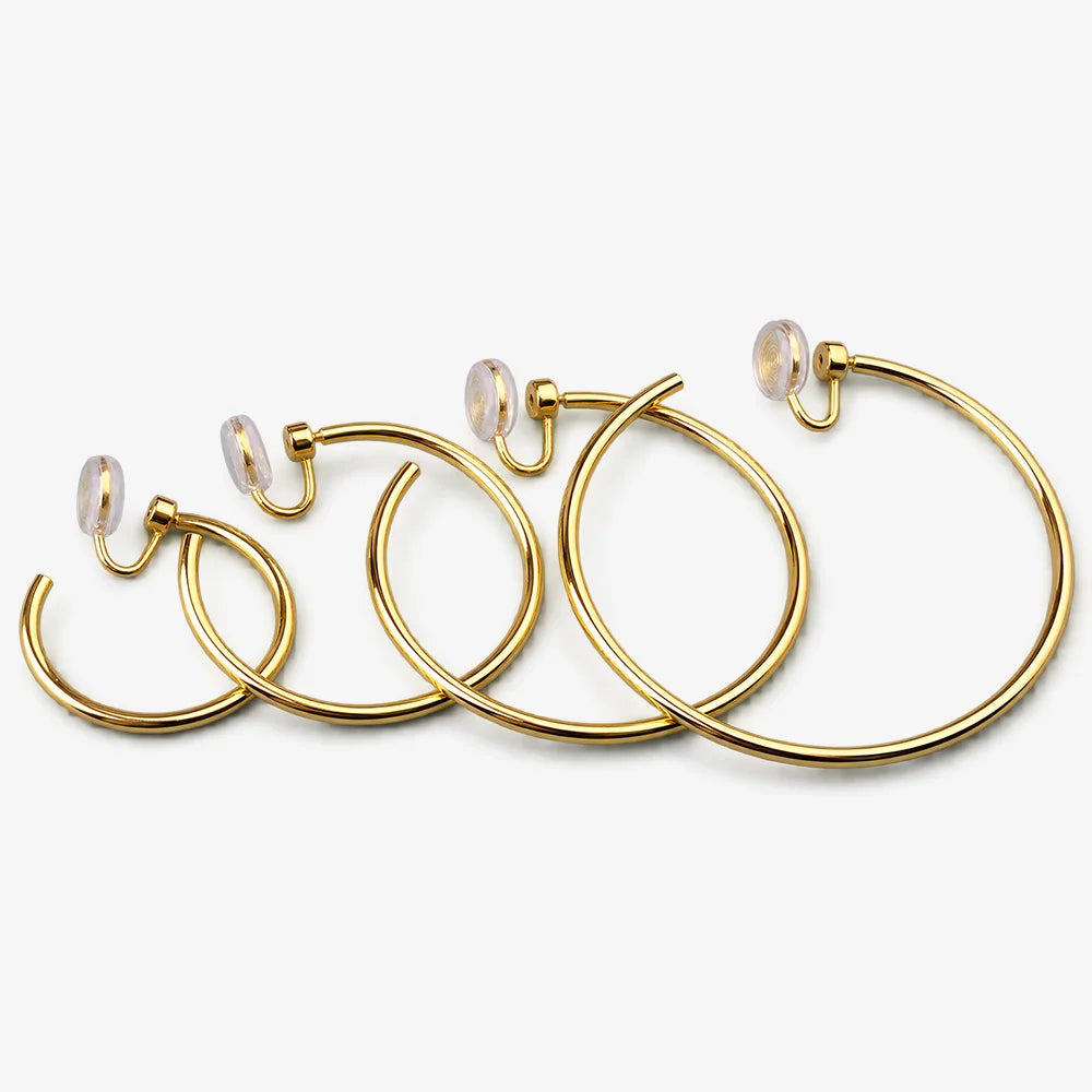 Thin gold hoop clip-on earrings in a range of sizes lined up from smallest to largest