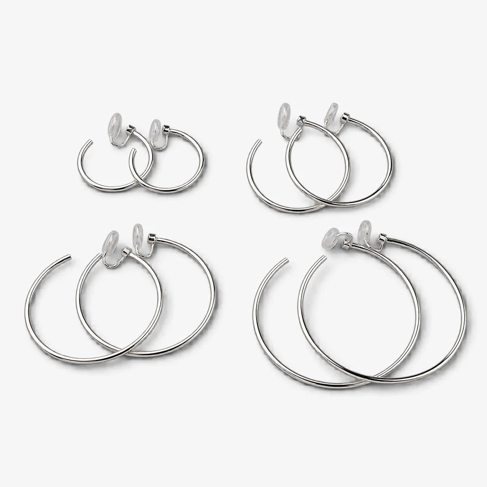 Four pairs of silver-tone hoop clip-on earrings arranged by size for comparison
