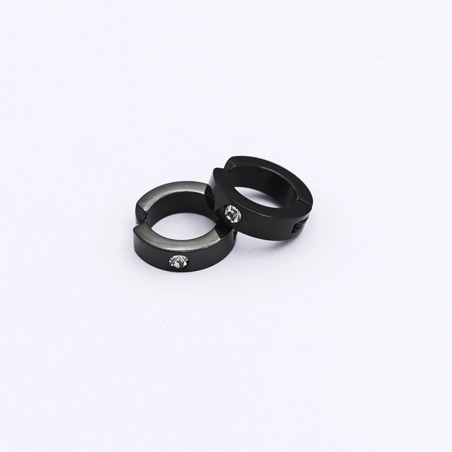 A pair of black spring-loaded clip-on hoop earrings with a subtle zircon accent, styled together on a clean white background.