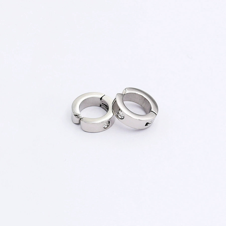 A pair of silver spring-loaded clip-on hoop earrings with a subtle zircon accent, styled together on a clean white background.