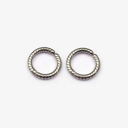 A pair of twisted rope textured clip-on hoop earrings in a polished silver finish, shown isolated on a white background.