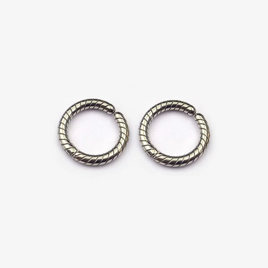 A pair of twisted rope textured clip-on hoop earrings in a polished silver finish, shown isolated on a white background.