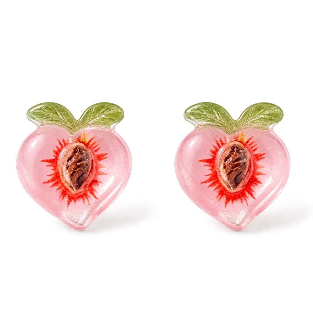 A pair of translucent pink resin peach magnetic stud earrings with green leaf details and a realistic pit center, isolated on a white background.