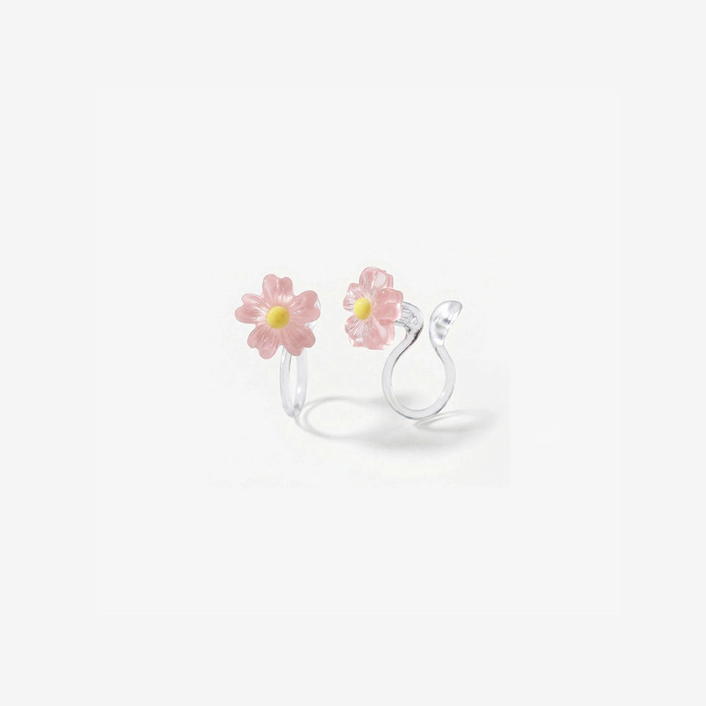 A pair of pink daisy flower earrings with a candy color translucent finish and stud clip-on backs.