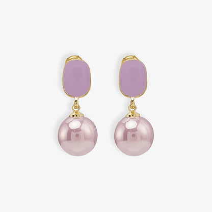 Pair of Purple Pearl Clip-On Drop Earrings displayed on a soft beige surface, capturing the elegant design and color contrast.