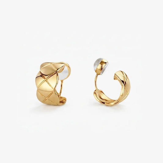 A pair of gold-toned quilted huggie clip on earrings featuring a lattice etched pattern.