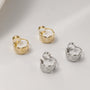 A collection of quilted huggie clip on earrings displayed in both white gold and gold finishes.