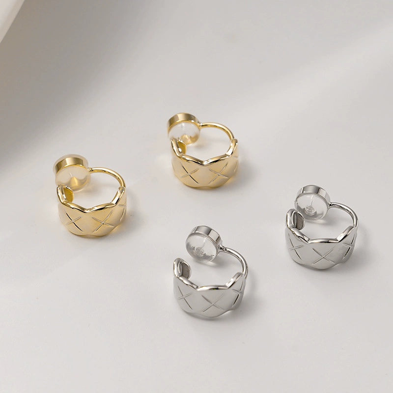 A collection of quilted huggie clip on earrings displayed in both white gold and gold finishes.