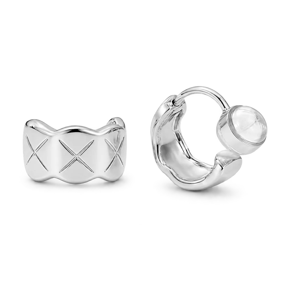 A pair of polished silver huggie hoop earrings on a clean white background. One earring is shown from the front, featuring a wavy, scalloped edge and an engraved X pattern, while the other is shown from the side/back, displaying its secure closure mechanism.