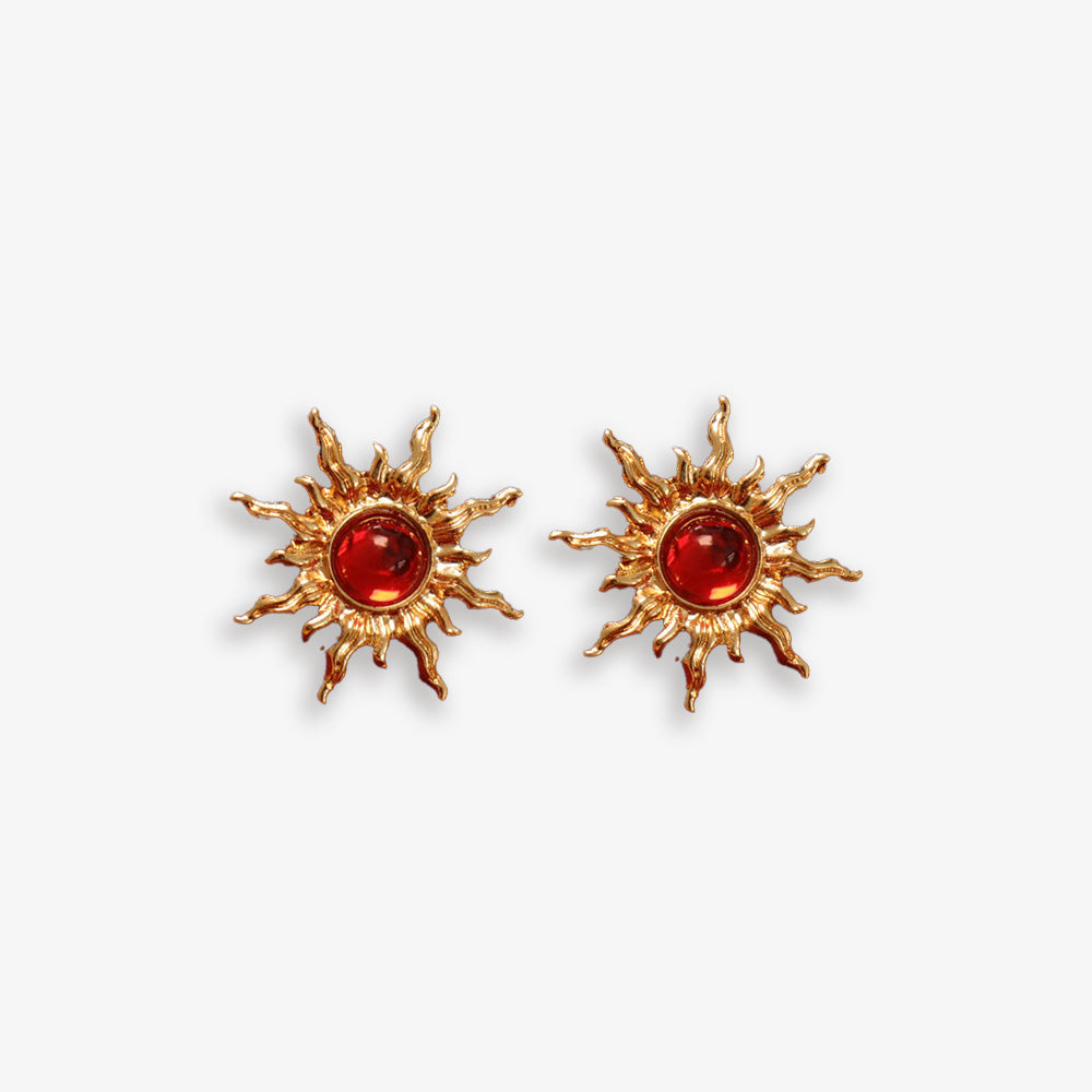 Gold sun clip-on ear studs with red faux rubies adding fiery power. Hinged back for non pierced ears. Embrace the celestial trend.