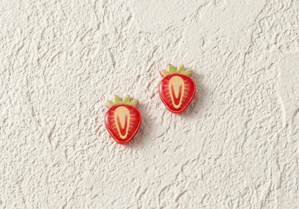 Detailed view of the strawberry slice resin earrings highlighting the glossy texture and secure magnetic clip-on mechanism.