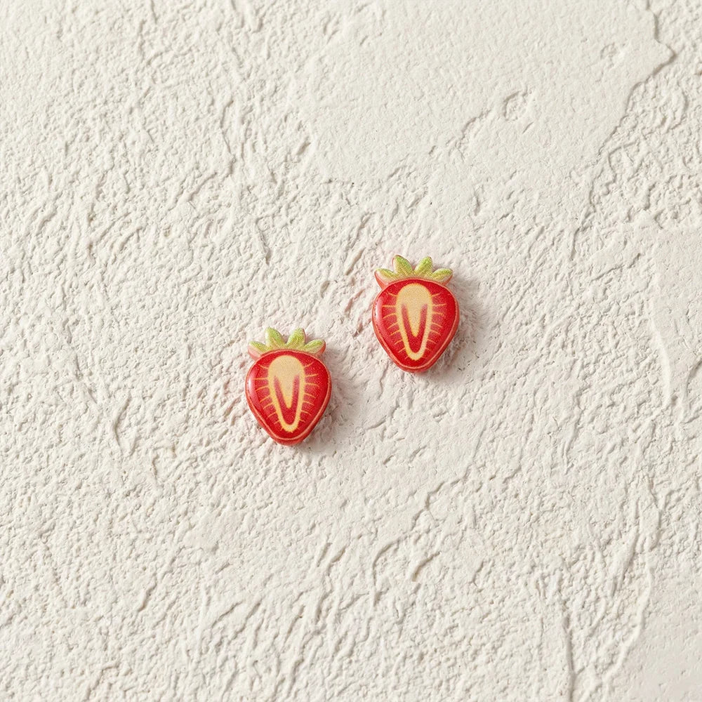 Detailed view of the strawberry slice resin earrings highlighting the glossy texture and secure magnetic clip-on mechanism.