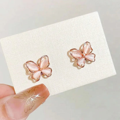 Close-up of rose gold butterfly magnetic earrings on a display card, highlighting the iridescent shimmer and non-piercing design.