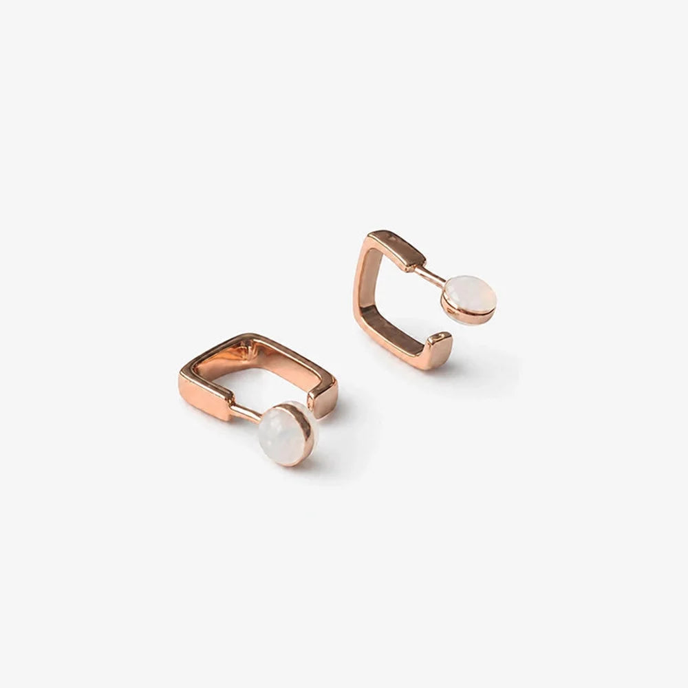 A pair of rose gold huggie square hoop earrings, shown on a clean white background.