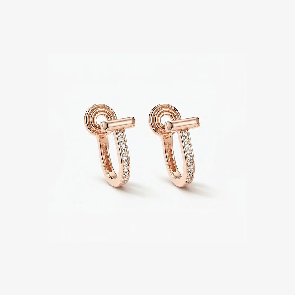 Close-up of rose gold T-motif huggie earrings featuring intricate micro pavé diamond settings on a clean white background.