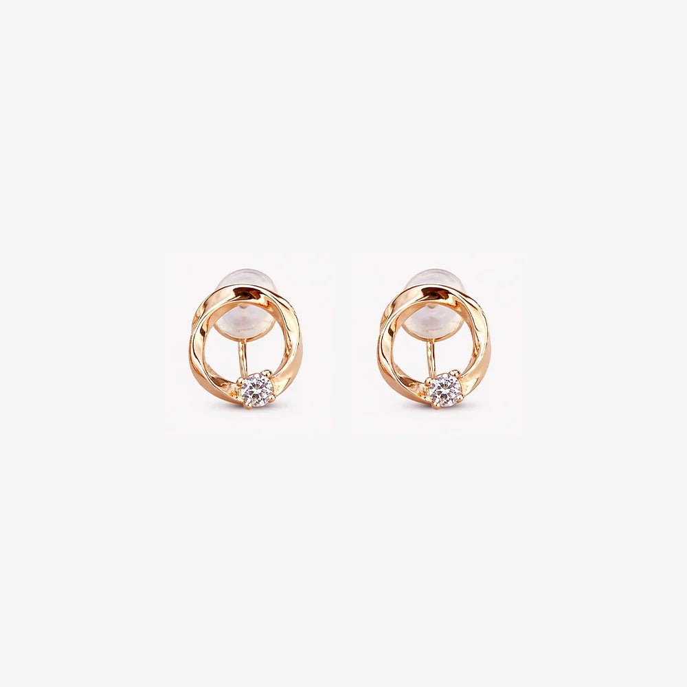 Pair of 18K rose gold twisted circle stud earrings with a central round solitaire stone on a clean white background.