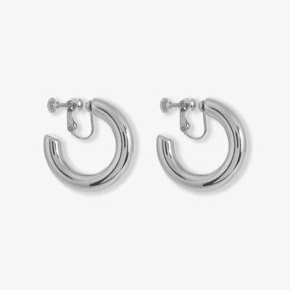 Silver-tone bold classic hoop clip-on earrings, crafted from high-shine alloy with screw-back fastenings. These earrings symbolize strength and self-love, aligning with current fashion trends for statement accessories.