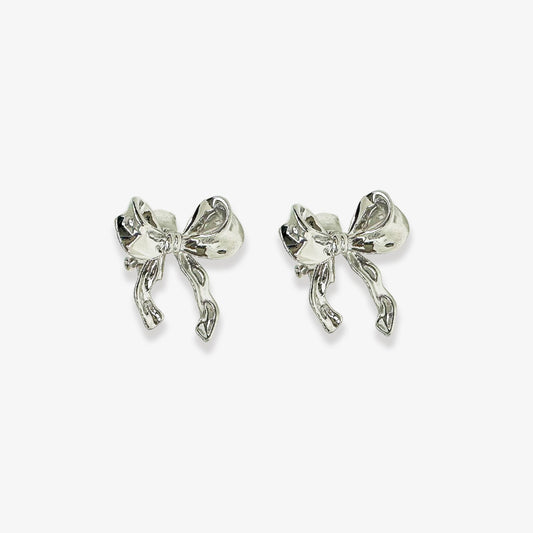 Sweet and girly silver clip-on stud earrings feature a delicate ribbon bow design, perfect for adding a touch of whimsical charm to any outfit. The secure hinge-back closure ensures a comfortable fit for non-pierced ears.