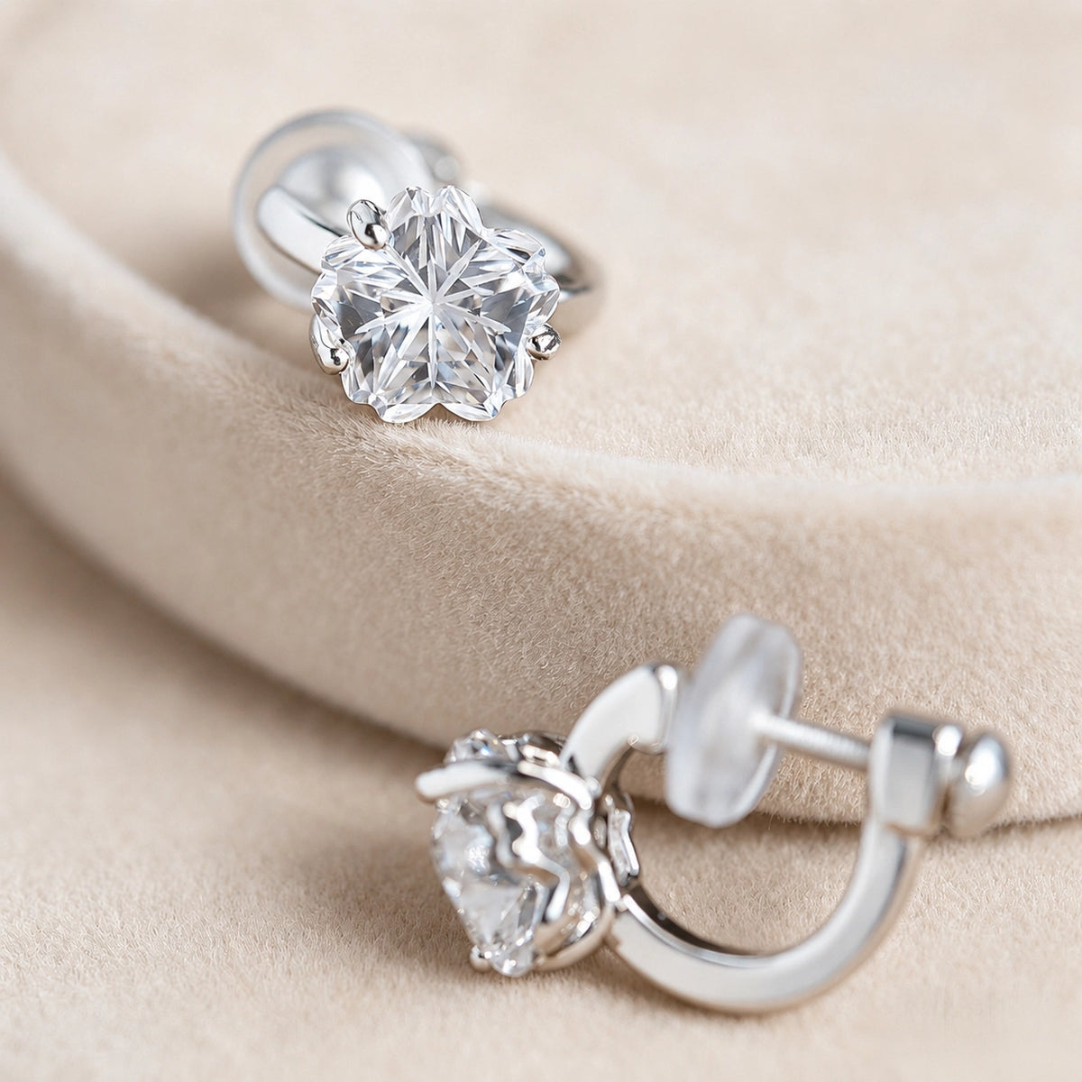 Close-up of the petal facets on clear sakura CZ clip-on studs resting on a beige display