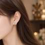 Clear flower cubic zirconia clip-on stud worn on a non-pierced earlobe