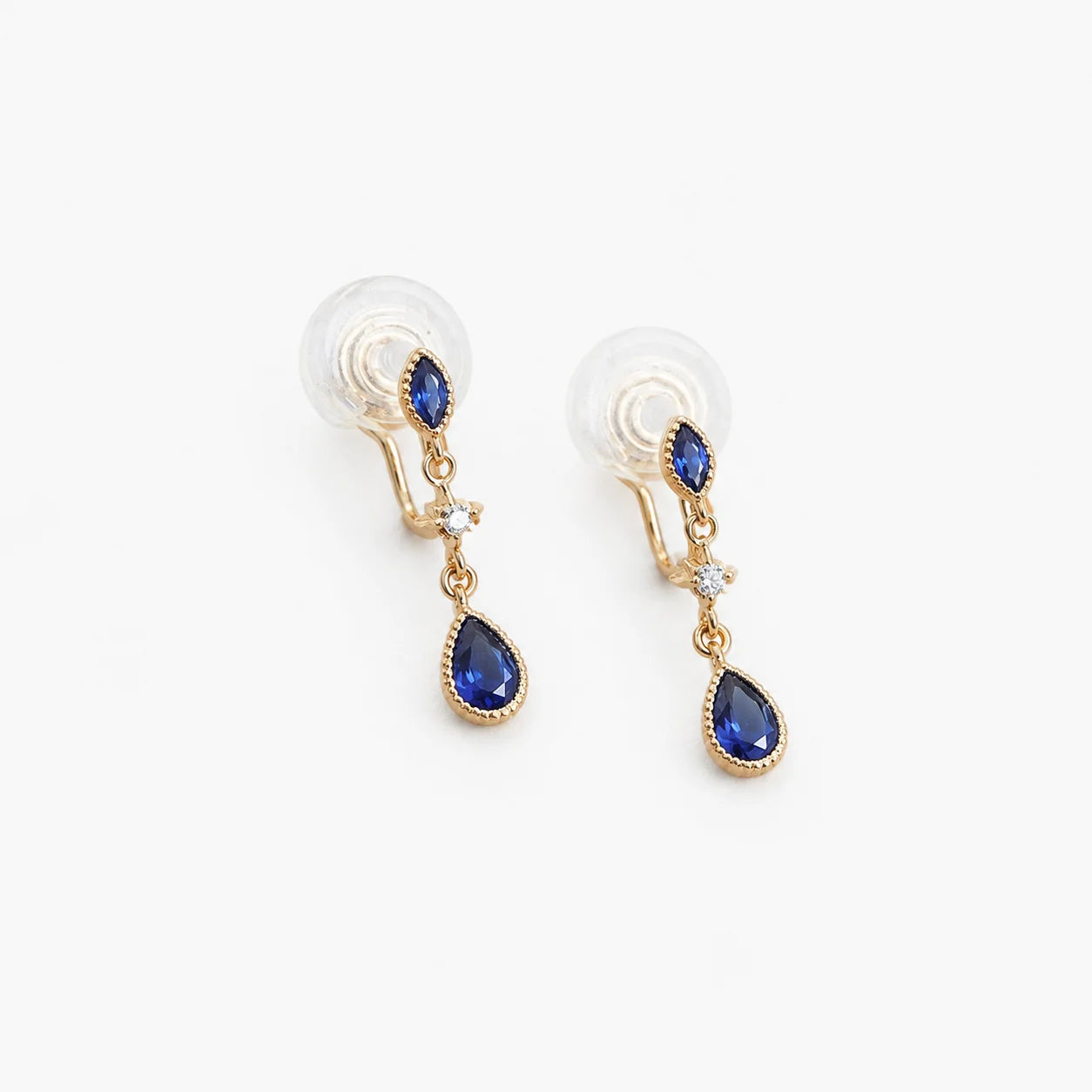 A pair of gold-toned dangle earrings with marquise-cut blue gemstones and teardrop-shaped blue gemstones, shown on a plain white background.