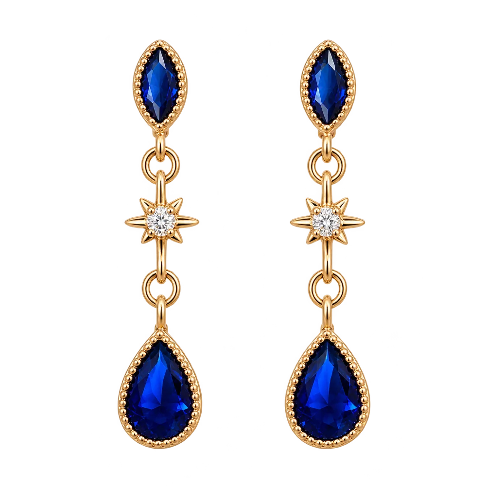 A pair of gold dangle earrings with marquise-cut blue gemstones, a star-shaped clear stone in the middle, and pear-shaped blue gemstones at the bottom