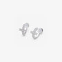 Angled detail of the cushioned clip on closure and pavé cross on silver huggie earrings