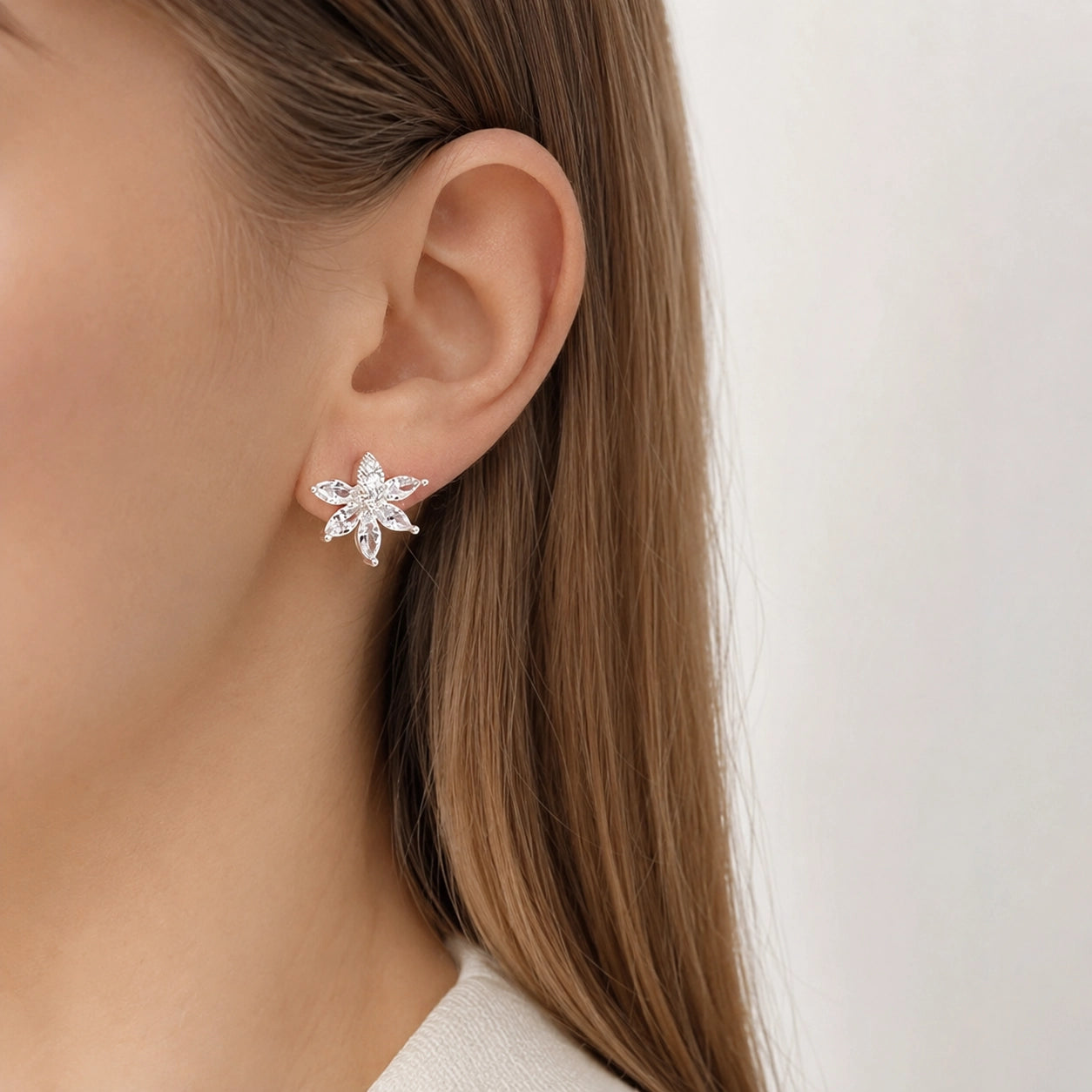 Woman wearing a silver crystal flower clip on earring on a non pierced ear